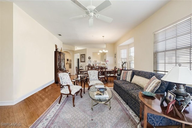 living room featuring wood-type flooring and ceiling fan with notable chandelier