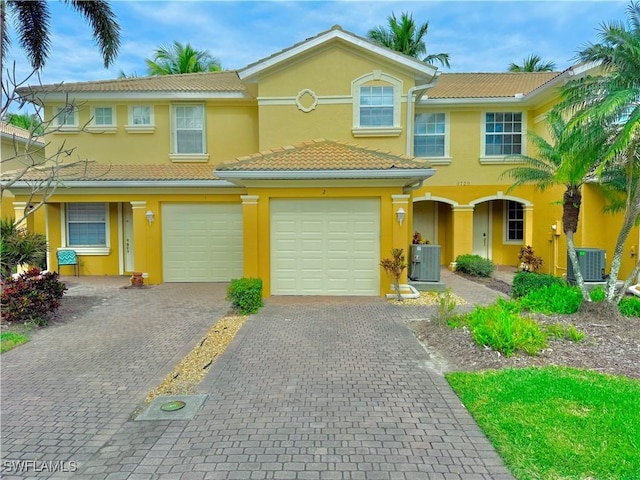 view of front of property featuring a garage and central AC