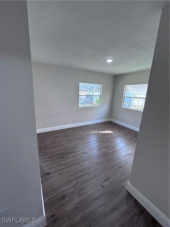 spare room with dark hardwood / wood-style flooring