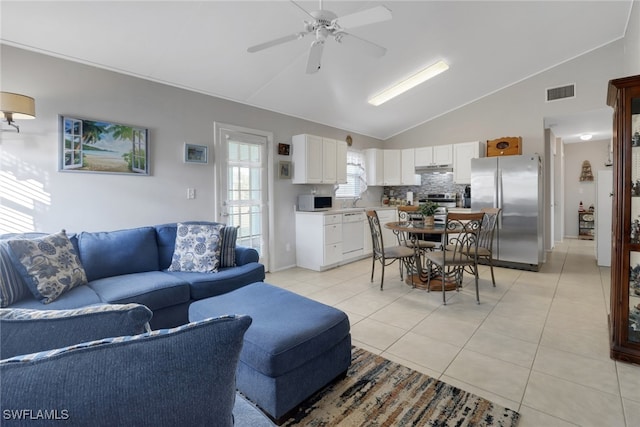 tiled living room featuring lofted ceiling and ceiling fan