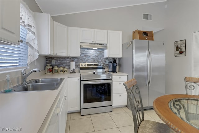 kitchen with light tile patterned flooring, lofted ceiling, sink, appliances with stainless steel finishes, and white cabinets