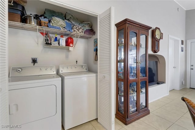 laundry area with washer and dryer and light tile patterned floors