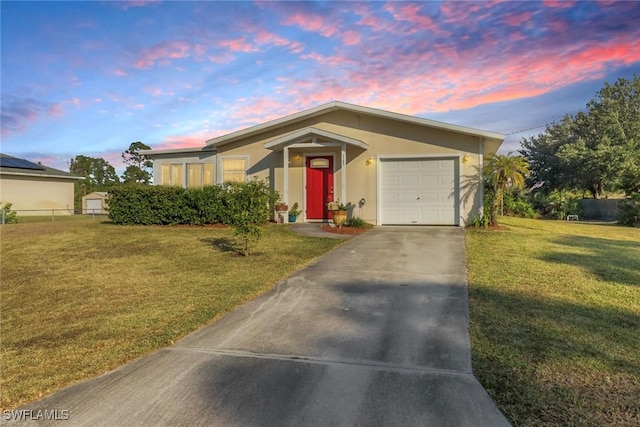 single story home featuring a garage and a yard