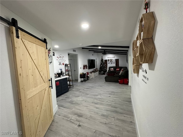 hallway featuring a barn door and light hardwood / wood-style floors