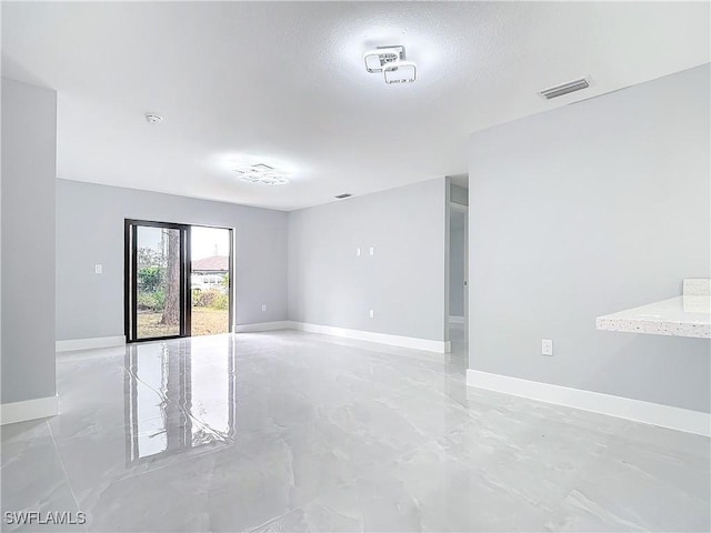 unfurnished room with a textured ceiling