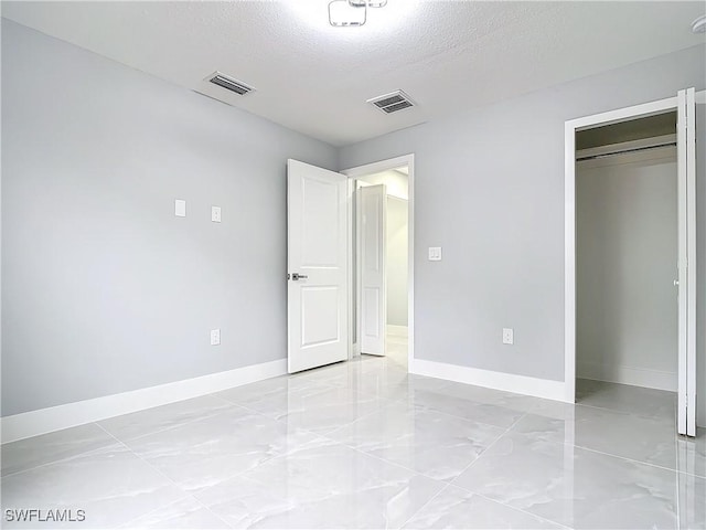 unfurnished bedroom with a closet and a textured ceiling