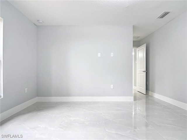 unfurnished room with a textured ceiling