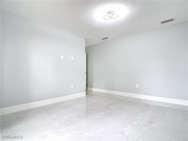 spare room with a textured ceiling