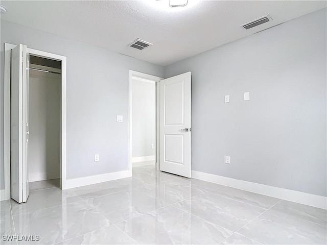 unfurnished bedroom featuring a closet and a textured ceiling