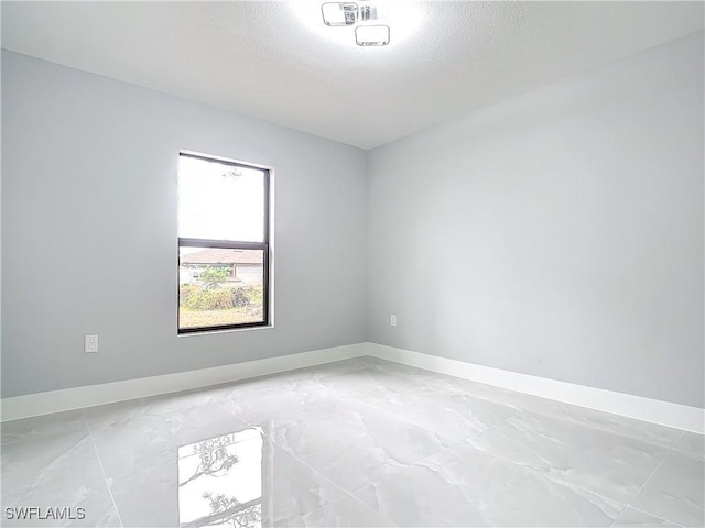 unfurnished room with a textured ceiling