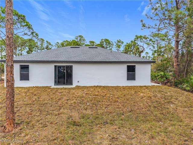 rear view of house featuring a yard