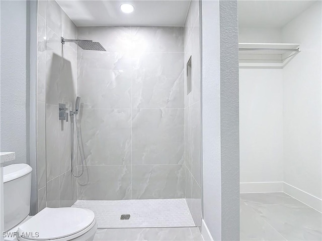 bathroom featuring toilet and tiled shower