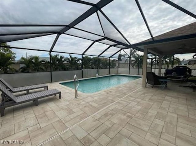 view of swimming pool featuring a patio and glass enclosure