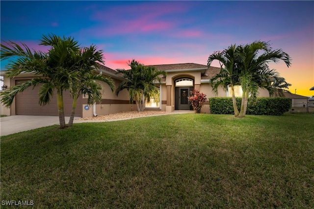 mediterranean / spanish house with a yard and a garage