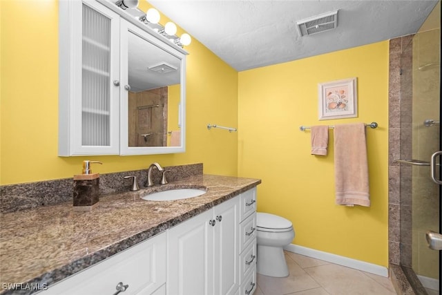 bathroom featuring vanity, a shower with shower door, tile patterned floors, and toilet