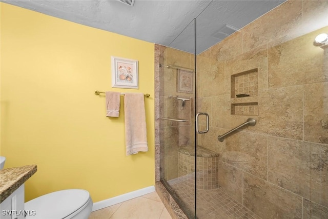 bathroom featuring vanity, a shower with shower door, tile patterned floors, and toilet