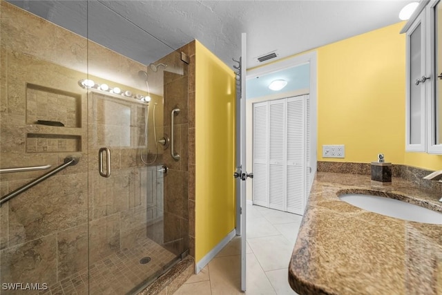 bathroom featuring vanity, a shower with door, and tile patterned floors