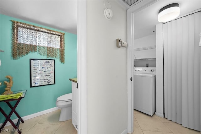 bathroom featuring tile patterned flooring, washer / clothes dryer, vanity, and toilet