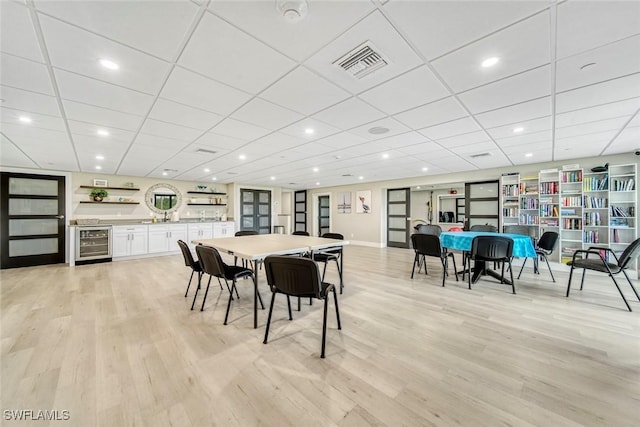 dining room with wine cooler and light wood-type flooring