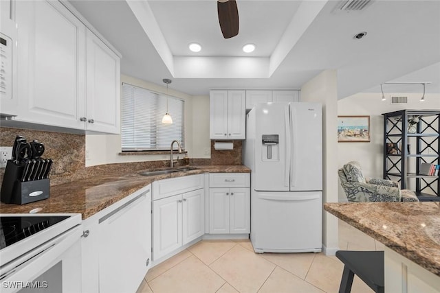 kitchen with sink, white appliances, decorative light fixtures, and white cabinets