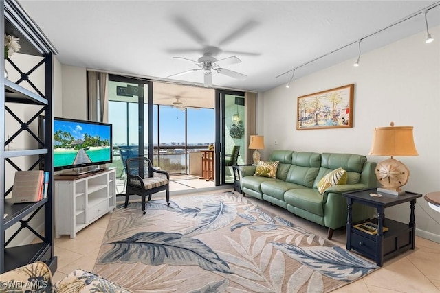 living room with light tile patterned flooring, a wall of windows, rail lighting, and ceiling fan