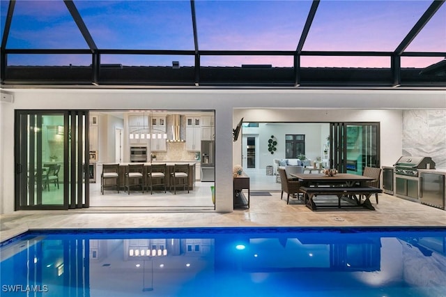 100 Templewood Ct, Marco Island, FL 34145 - pool at dusk featuring grilling area and an outdoor pool