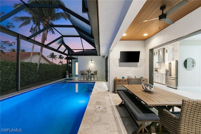 view of pool featuring ceiling fan, a patio area, and a lanai