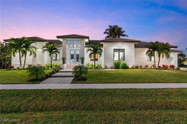 view of front of property featuring a lawn and french doors