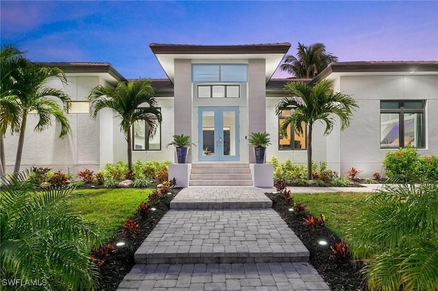 exterior entry at dusk featuring french doors