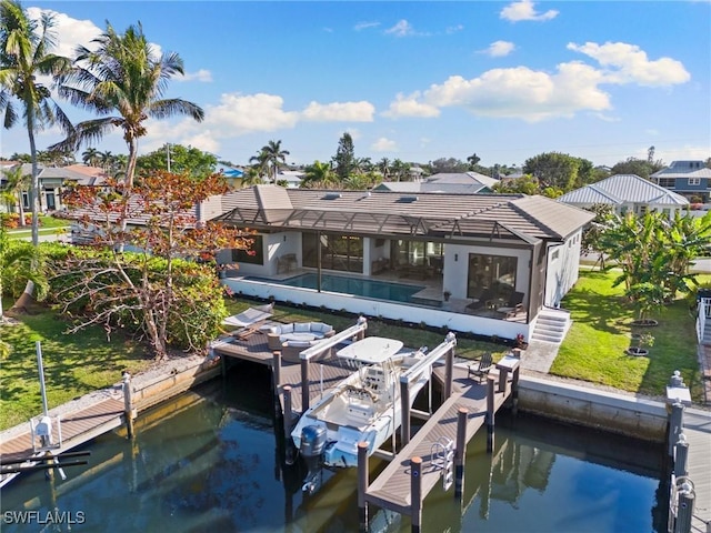 dock area featuring a lanai, a lawn, and a water view