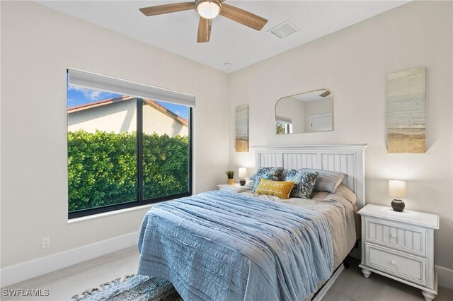 bedroom featuring ceiling fan, light tile patterned flooring, and multiple windows