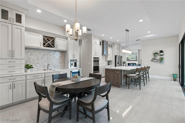 dining room featuring a notable chandelier, sink, and light tile patterned flooring