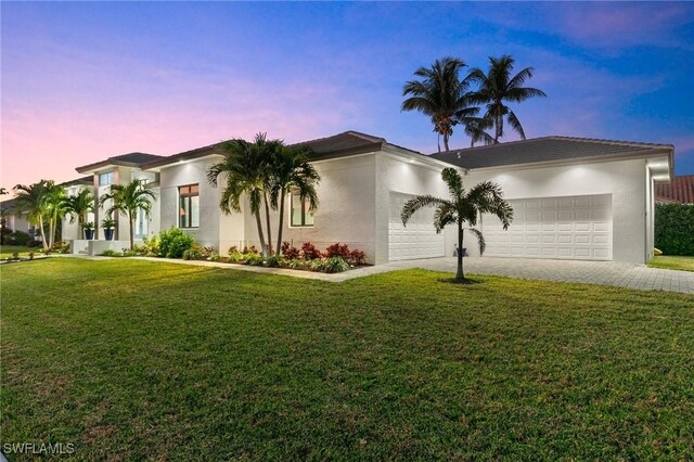 view of front of home featuring a garage and a lawn