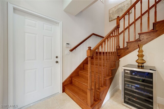 staircase featuring tile patterned flooring and beverage cooler