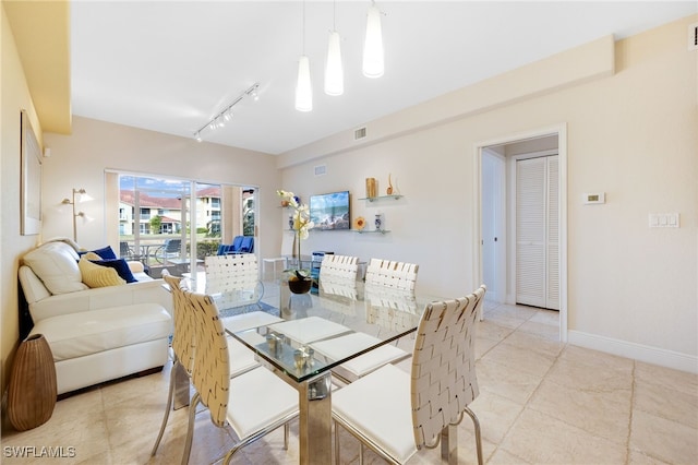 tiled dining area featuring rail lighting