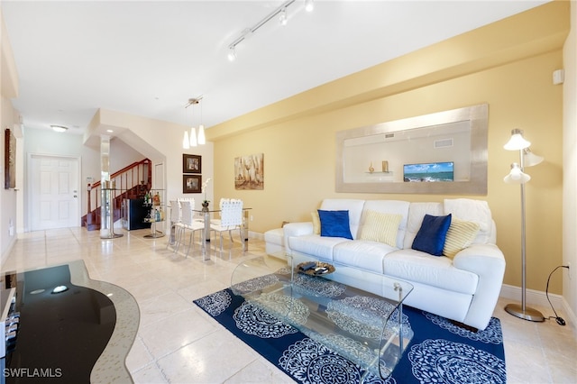 tiled living room featuring rail lighting