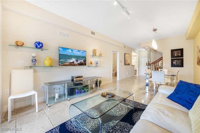 tiled living room featuring rail lighting