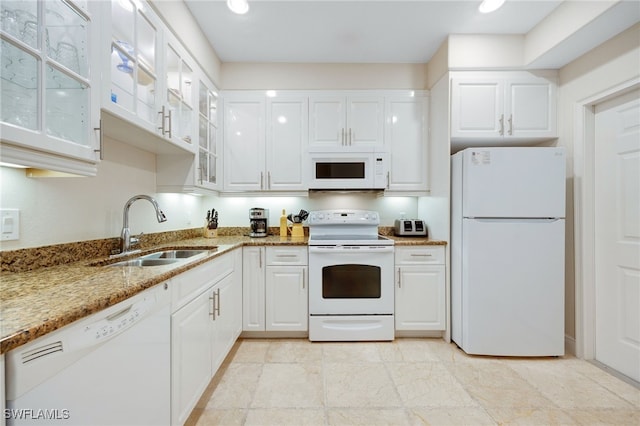 kitchen with sink, white appliances, white cabinets, and light stone countertops