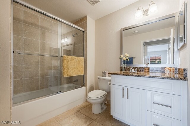 full bathroom featuring toilet, shower / bath combination with glass door, tile patterned floors, and vanity