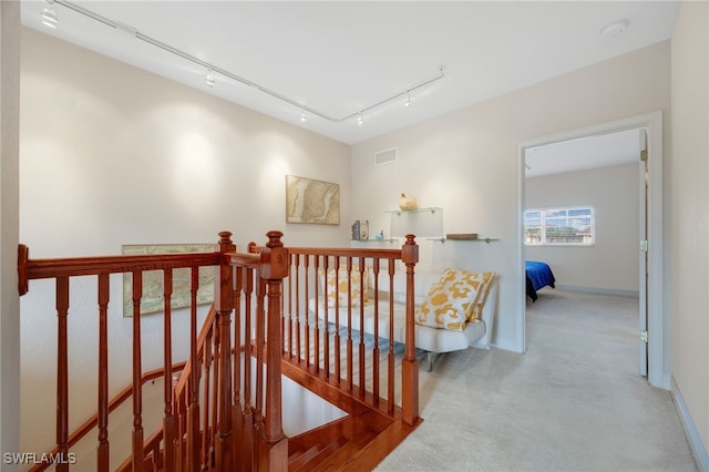 hallway featuring carpet flooring and track lighting