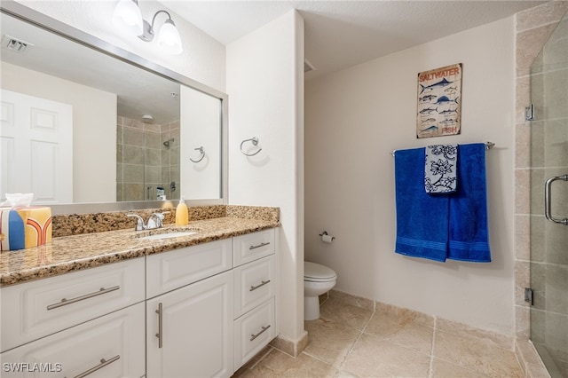 bathroom with a shower with shower door, toilet, and vanity