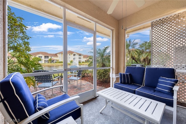 sunroom / solarium with a water view and ceiling fan