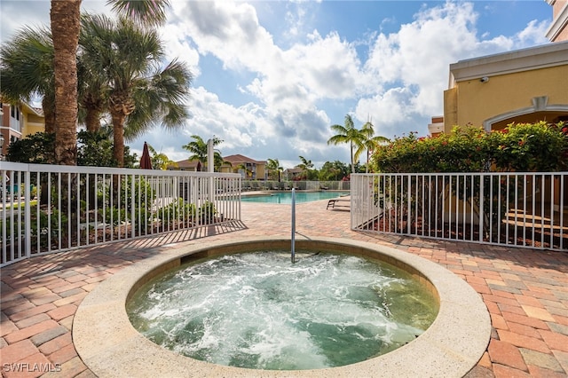 view of swimming pool featuring a community hot tub and a patio