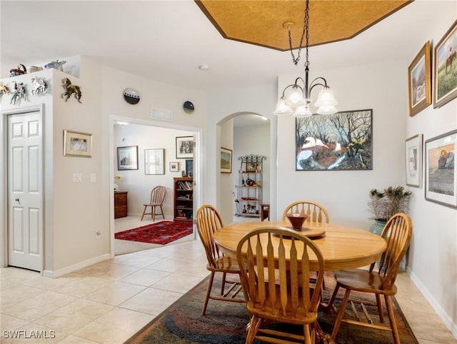 tiled dining room with an inviting chandelier