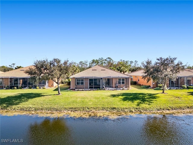 back of house featuring a lawn and a water view