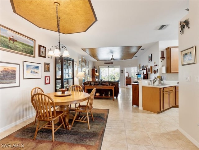 dining room featuring sink, light tile patterned flooring, and ceiling fan with notable chandelier