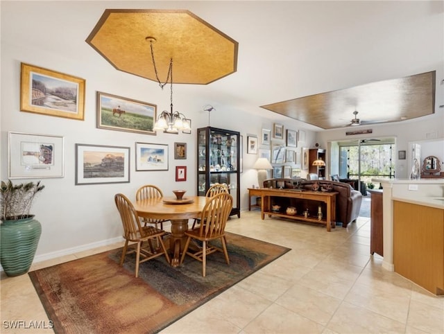 tiled dining area with ceiling fan with notable chandelier