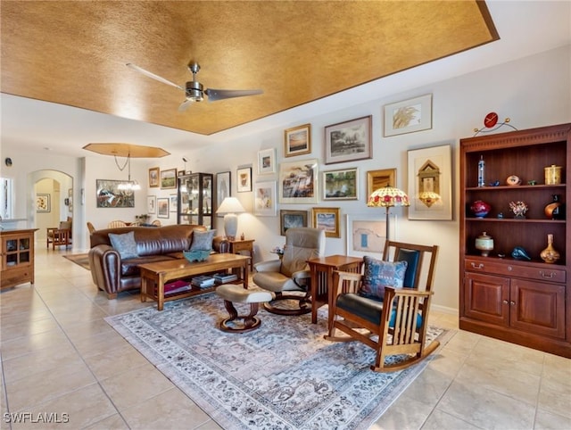 living room featuring ceiling fan with notable chandelier and light tile patterned floors