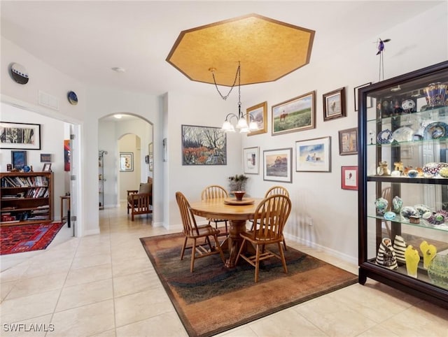 tiled dining space featuring a notable chandelier