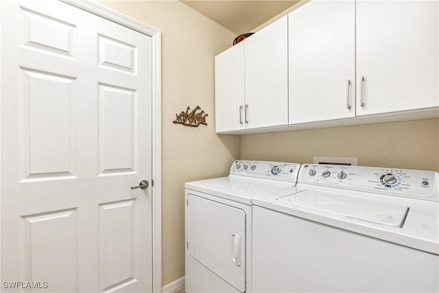 washroom with cabinets and washer and dryer